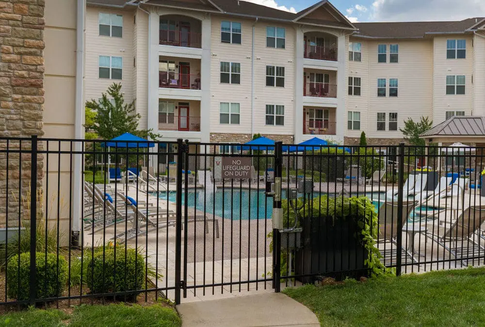 Gated pool area in front of a multi-story apartment building