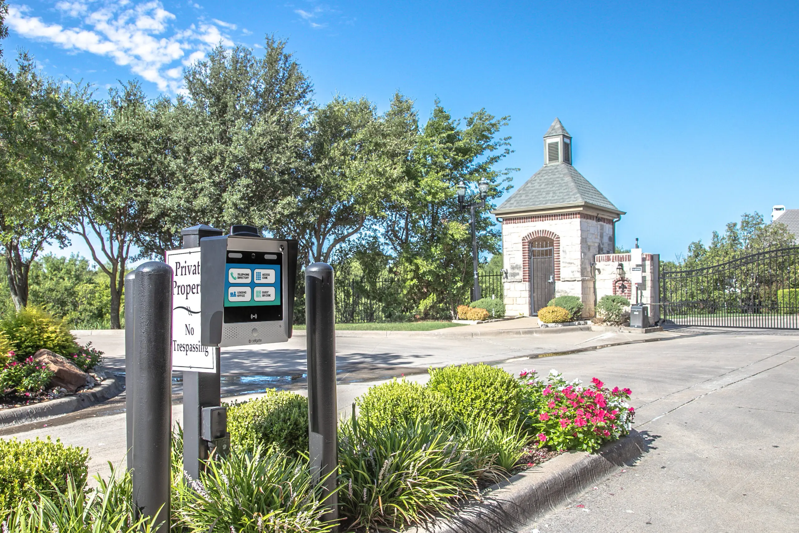 CellGate Watchman telephone entry system installed at a gated community entrance with stone guard house and landscaping