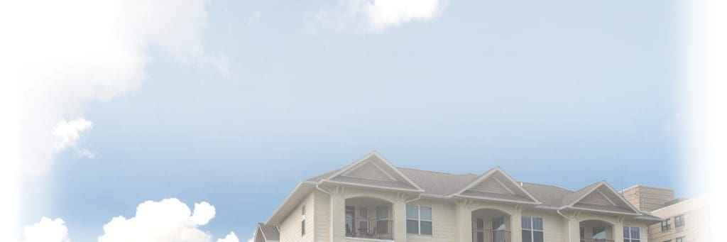 A cloudy sky with the top of an apartment building