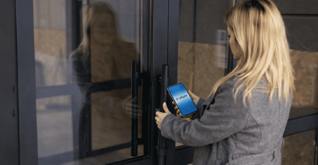 Woman about to enter a door using a CellGate Entría door controller key on a mobile app